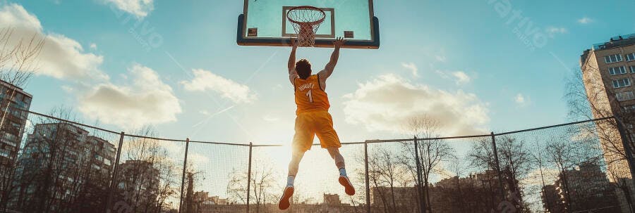 Jogador de basquete masculino branco em uniforme laranja enterrando em quadra urbana