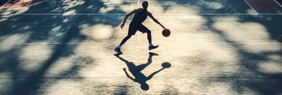 Homem jogador de basquete driblando na quadra externa com sombras
