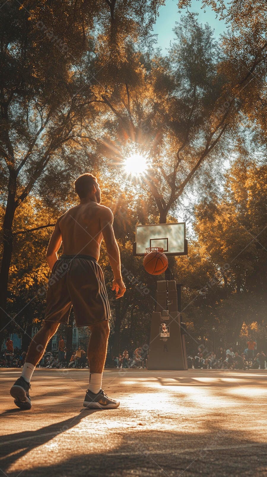 Homem atlético jogando basquete em quadra com luz dourada do pôr do sol