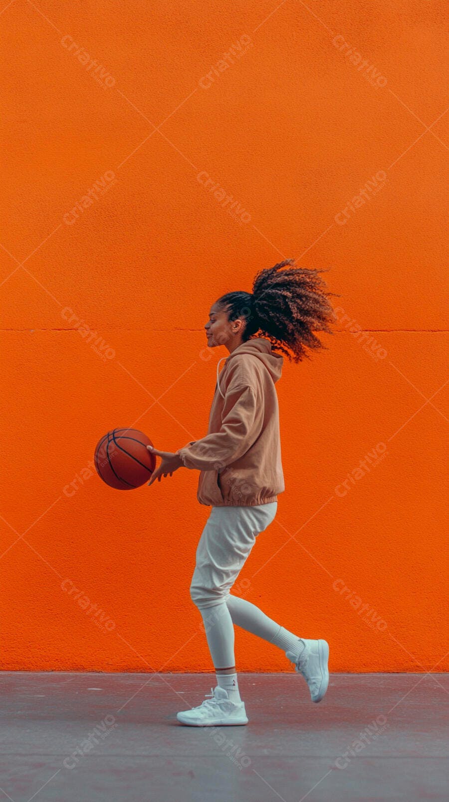 Mulher jovem afro-americana com basquete em fundo laranja vibrante