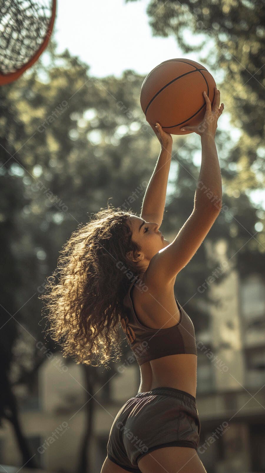 Mulher atleta de cabelos cacheados arremessando basquete em quadra ensolarada