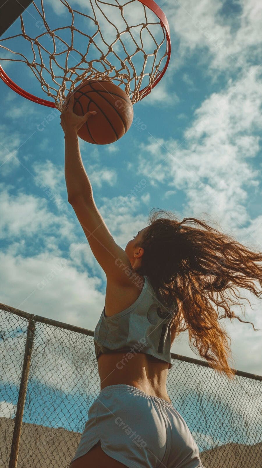 Mulher atleta jogando basquete com bola na cesta em quadra externa