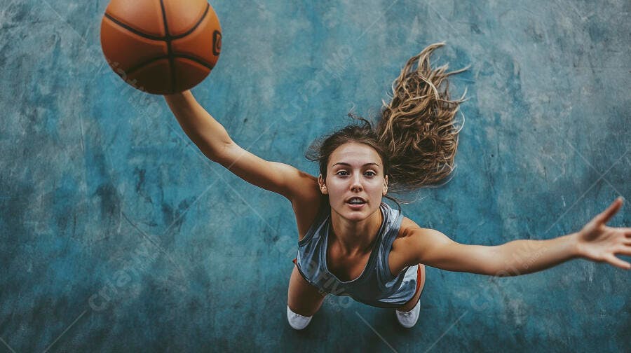 Menina jovem caucasiana jogando basquete em quadra azul com bola laranja