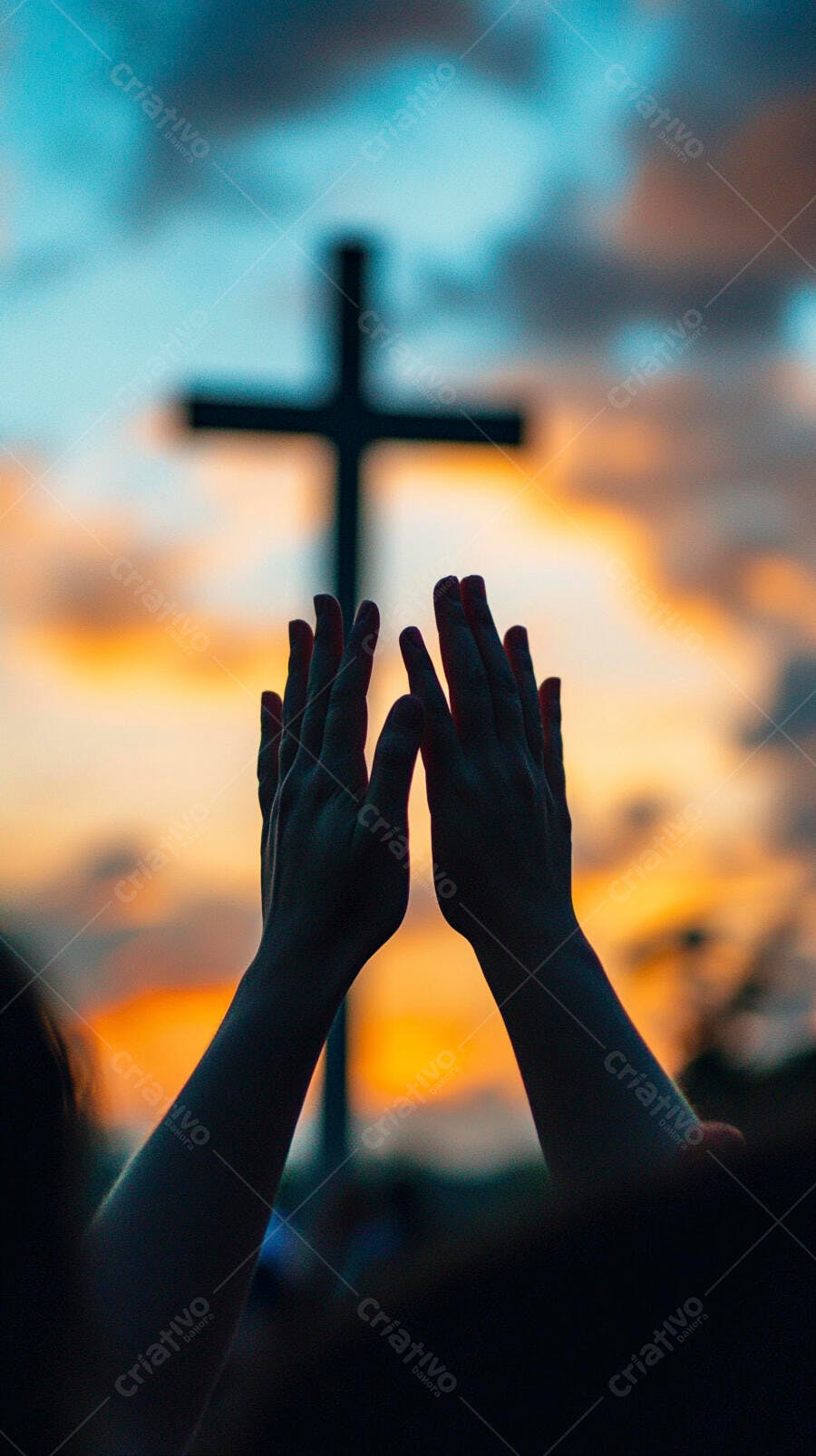 Mãos em oração silhueta contra pôr do sol laranja e azul com cruz ao fundo