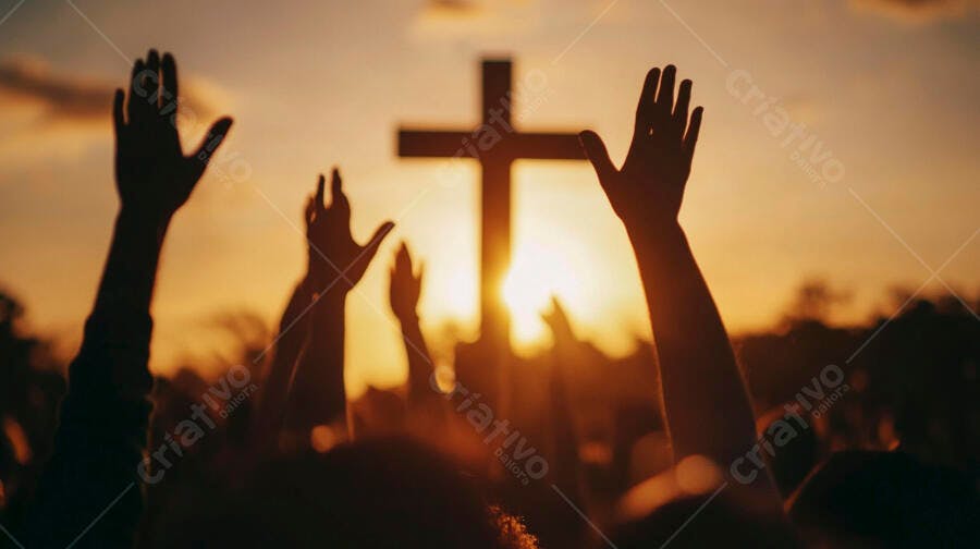 Mãos erguidas em adoração a cruz silhueta ao pôr do sol