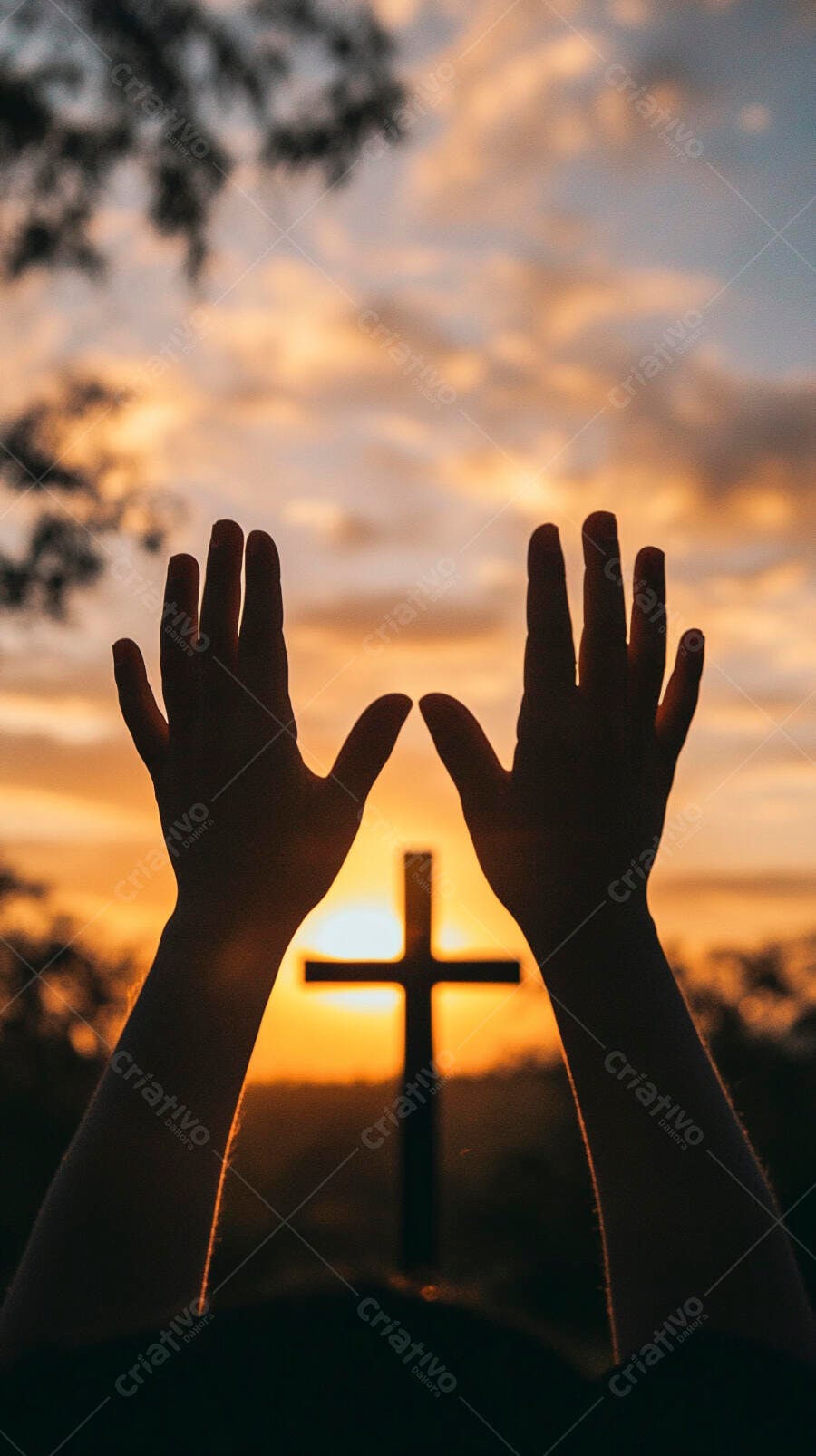 Mãos erguidas em oração com cruz silhueta no pôr do sol alaranjado