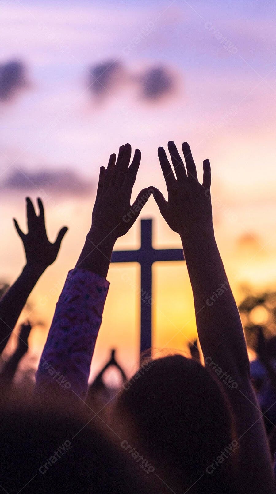 Mãos erguidas em adoração ao entardecer com uma cruz no horizonte