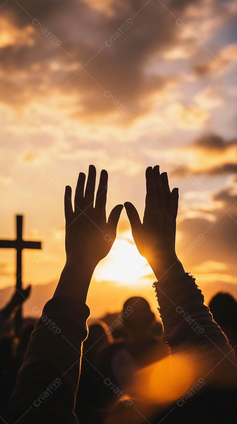 Mãos levantadas em adoração durante culto ao pôr do sol com cruz no horizonte