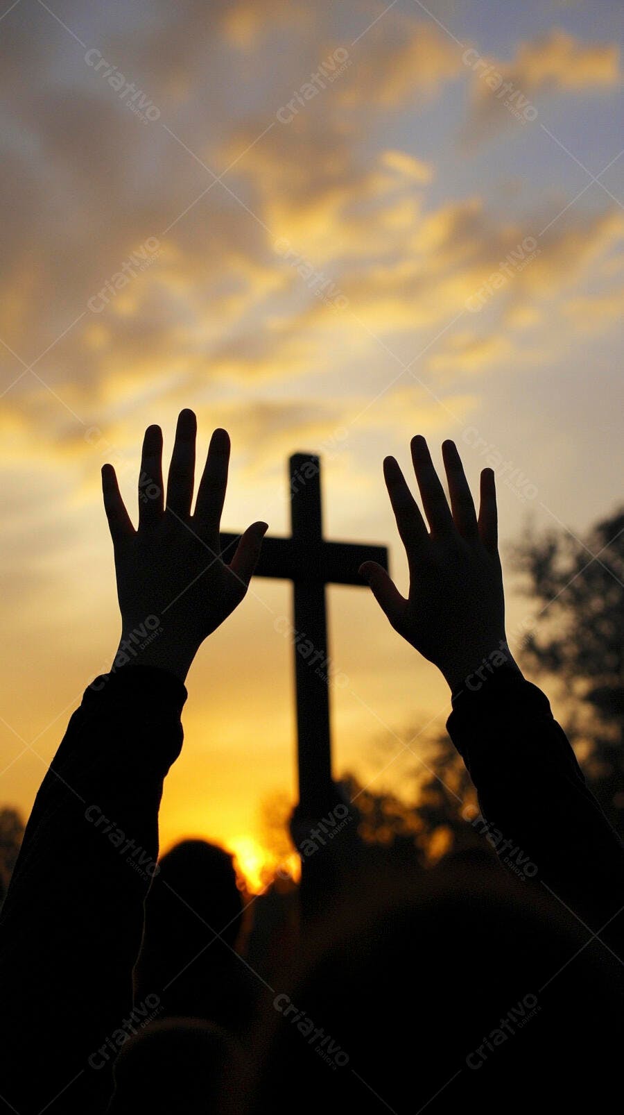Mãos erguidas em adoração com cruz ao pôr do sol dourado