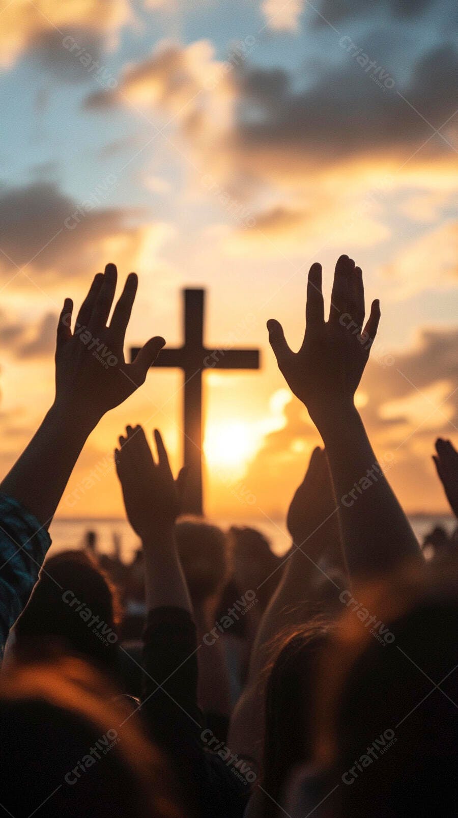 Mãos de fiéis levantadas em adoração diante da cruz ao pôr do sol laranja