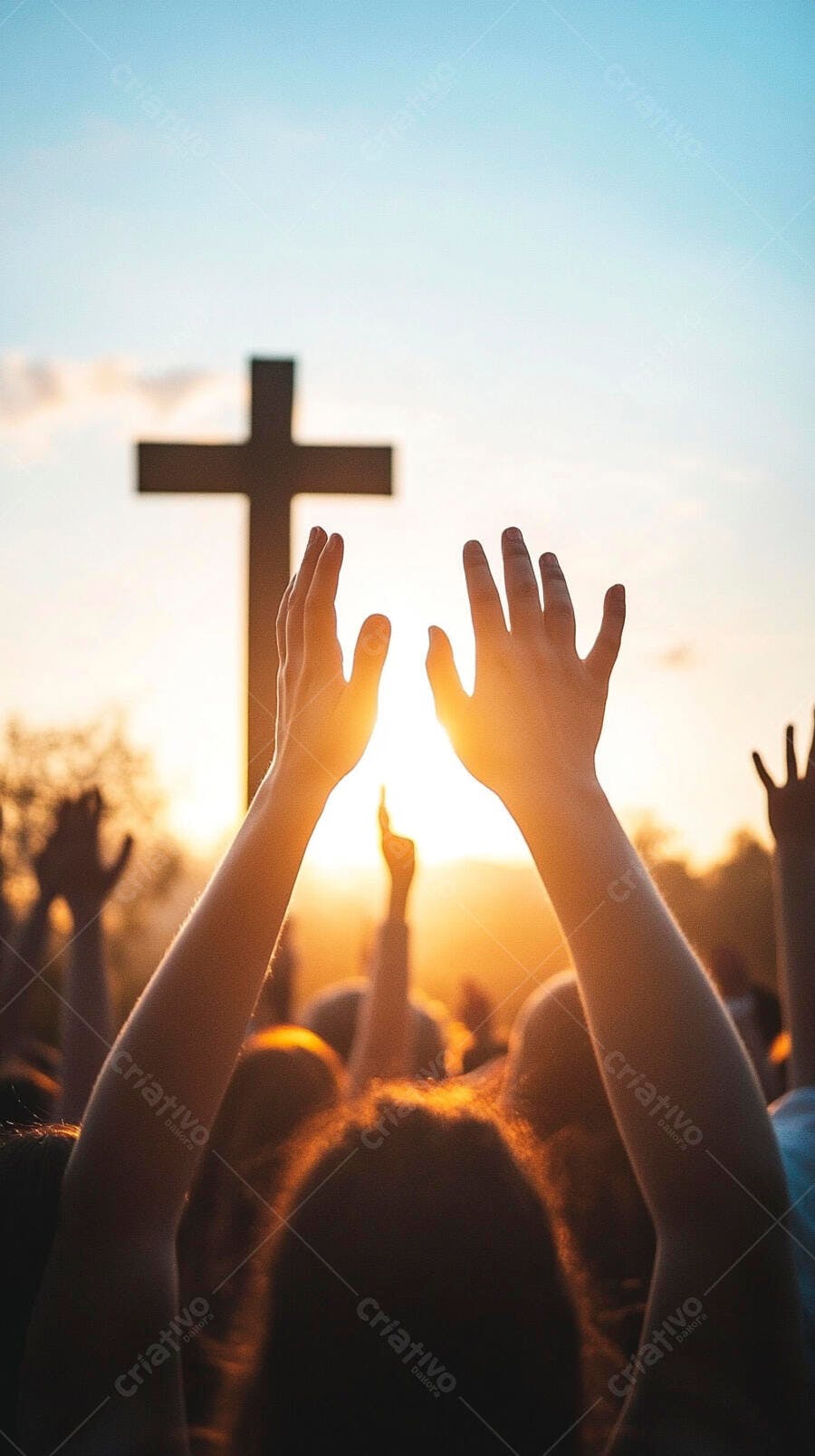 Pessoas com mãos levantadas adorando ao pôr do sol com cruz