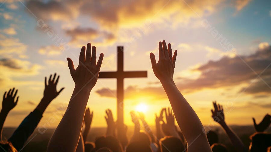 Pessoas com mãos levantadas em adoração sob cruz ao pôr do sol dourado