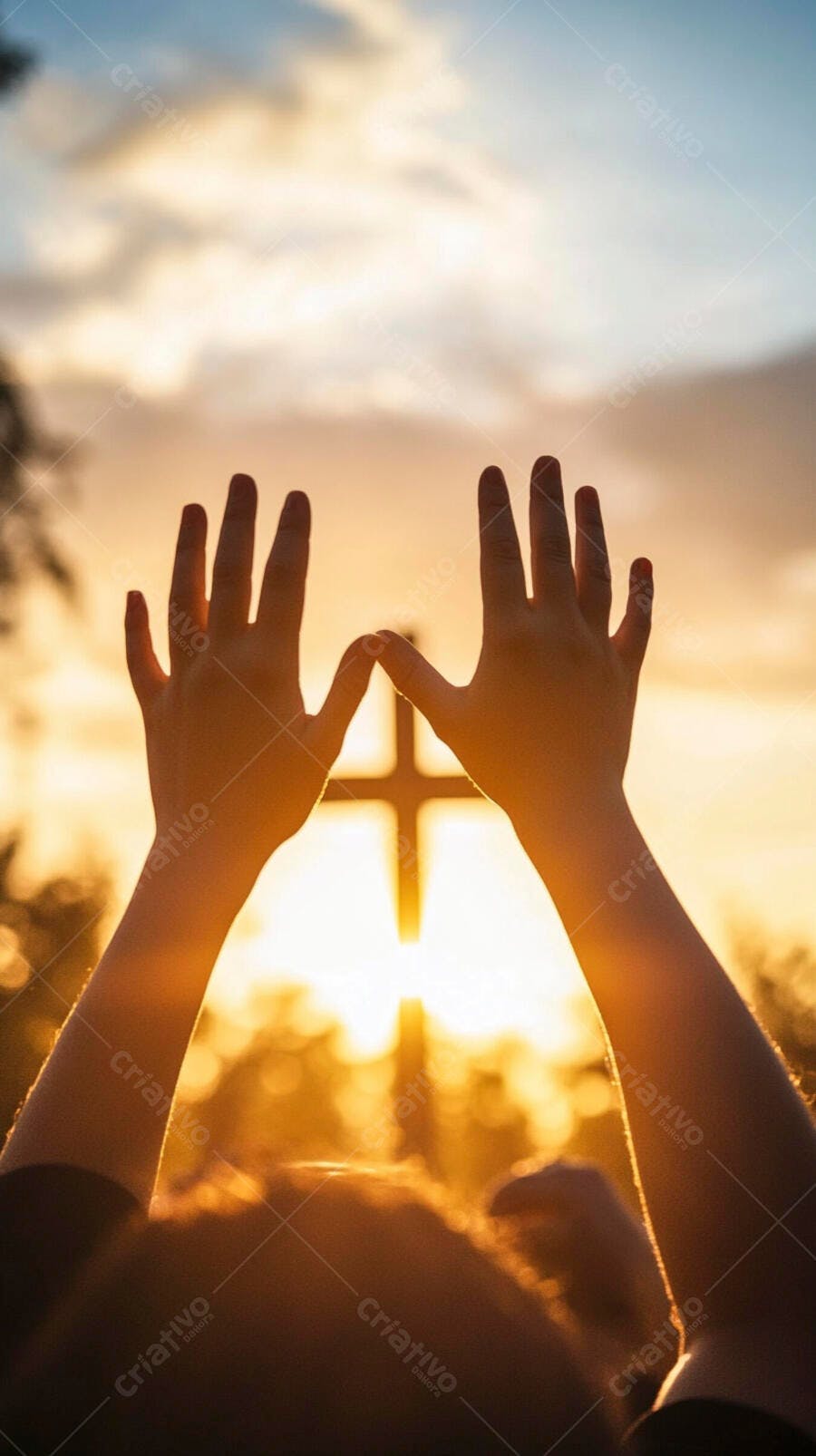 Mãos em oração contra cruz iluminada pelo pôr do sol esperançoso