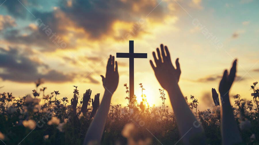 Cruz e mãos em adoração ao pôr do sol em campo de flores