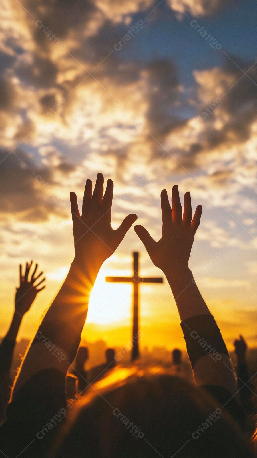 Mãos erguidas em adoração com cruz ao pôr do sol dourado e céu nublado