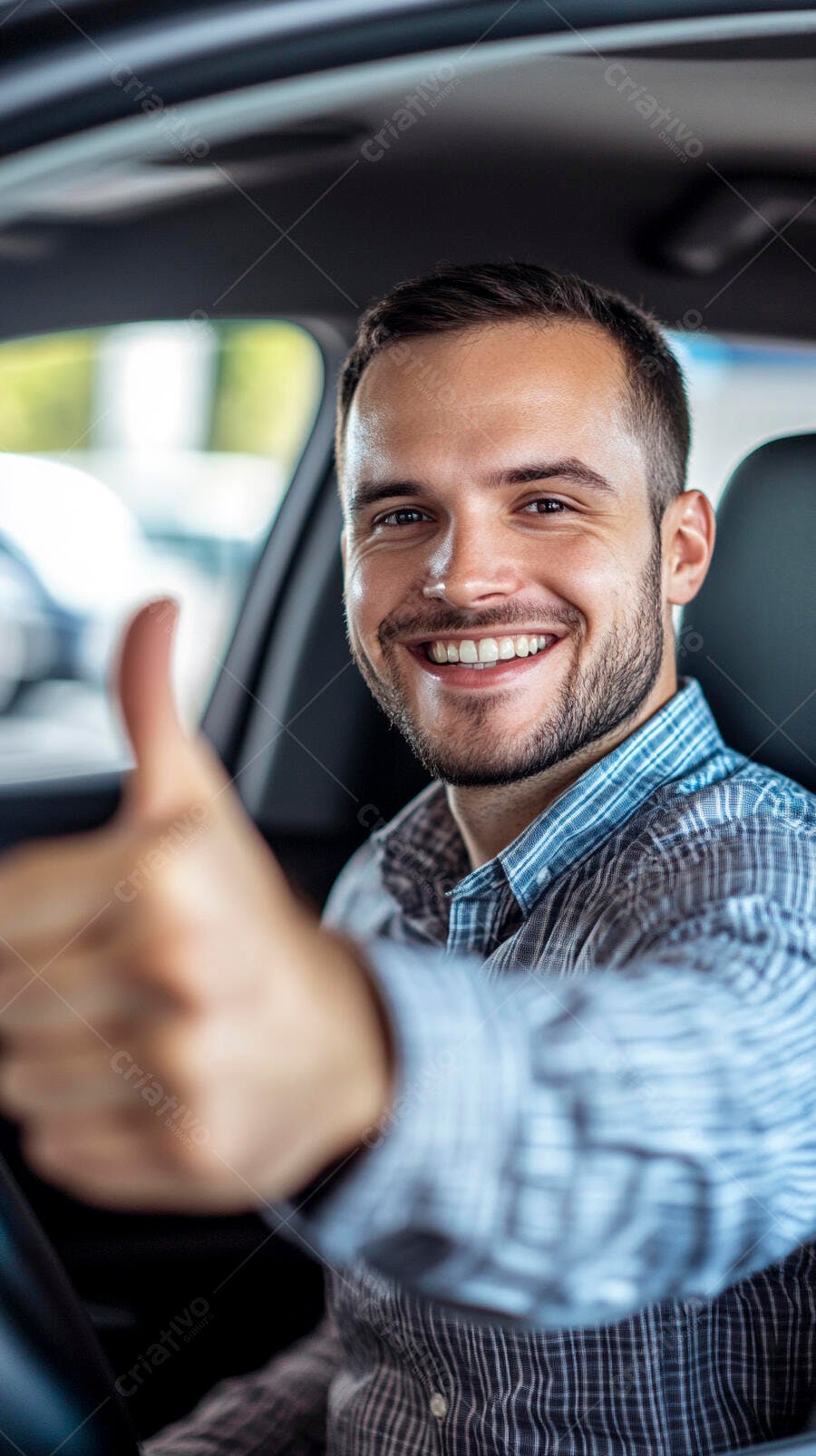 Homem jovem barbudo feliz dentro do carro camisa xadrez azul com polegar para cima