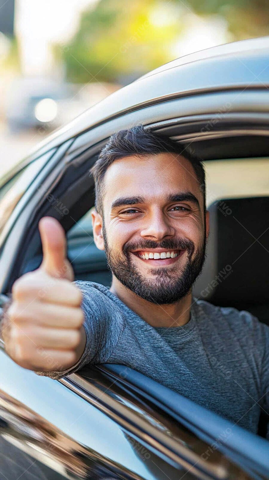 Homem feliz de camiseta cinza sorrindo e dando polegar para cima no carro