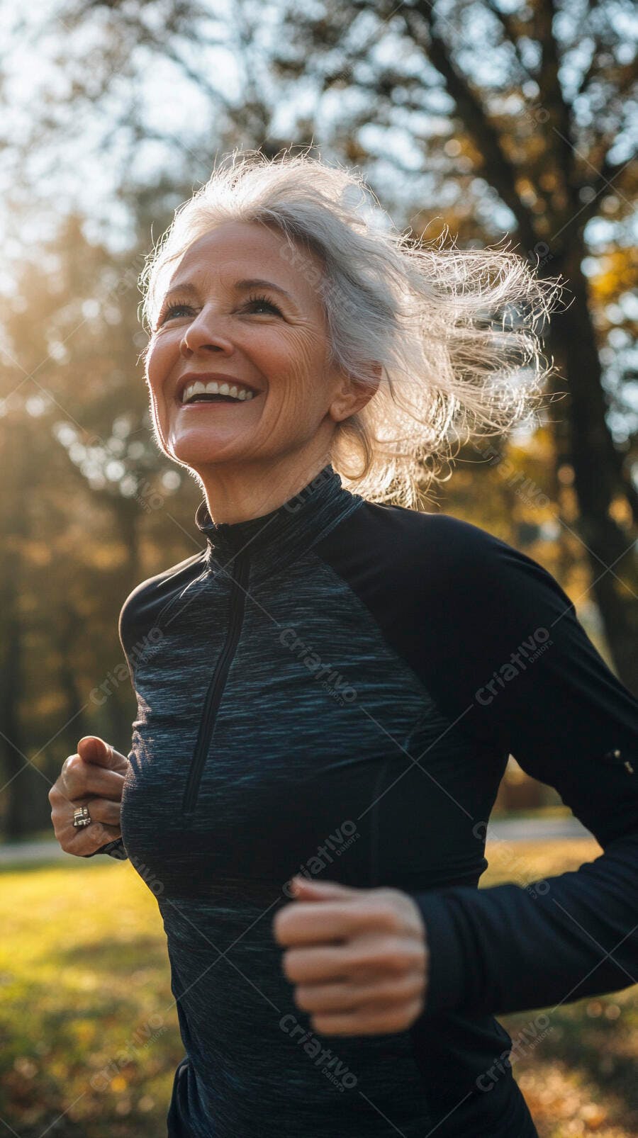 Mulher idosa feliz de cabelo grisalho correndo no parque ao por do sol