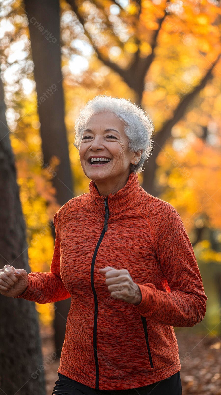 Mulher idosa feliz de jaqueta laranja correndo no parque no outono