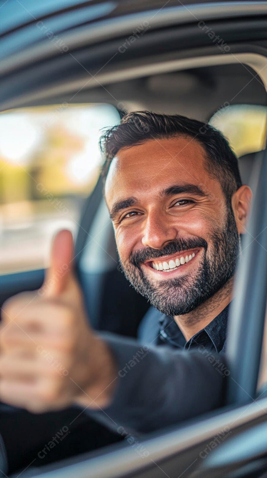 Homem moreno barbudo sorrindo no carro dando polegar para cima