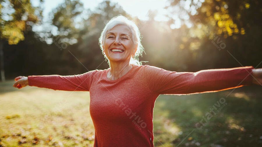 Mulher idosa sorridente de braços abertos aproveitando o sol no parque