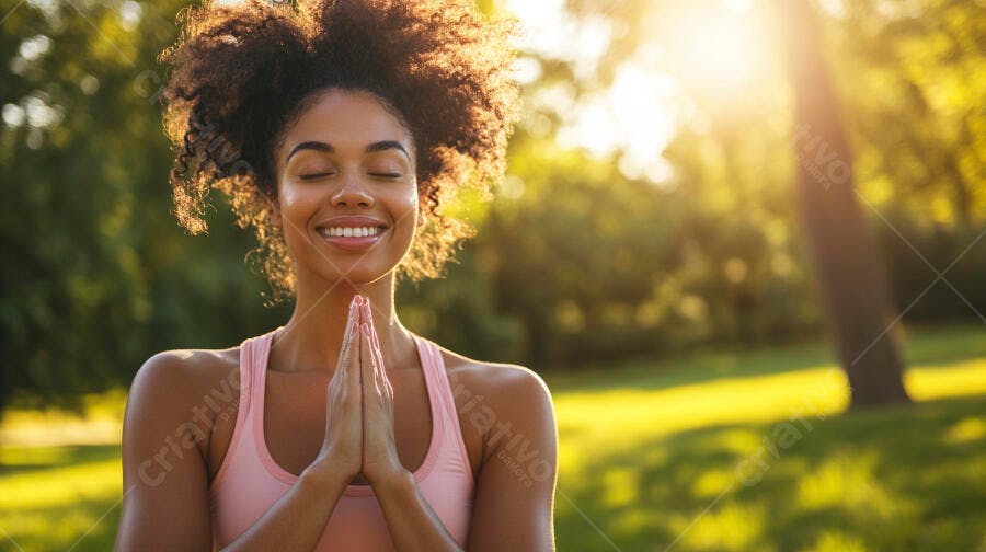 Mulher negra sorrindo praticando yoga no parque ao pôr do sol