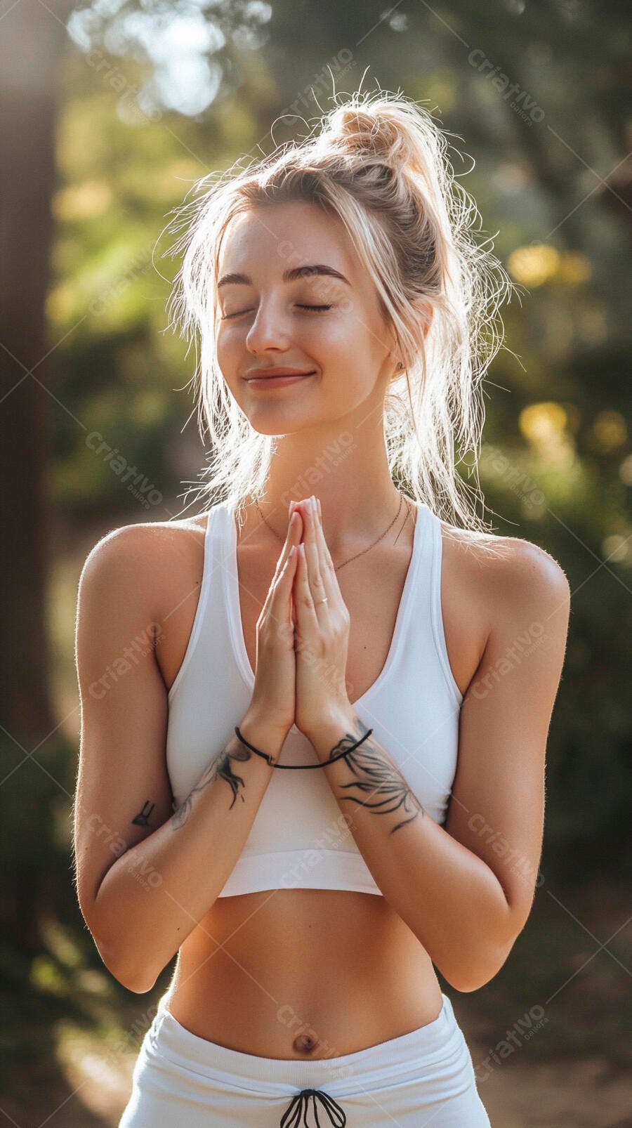 Mulher loira caucasiana meditando em parque com top branco ao sol