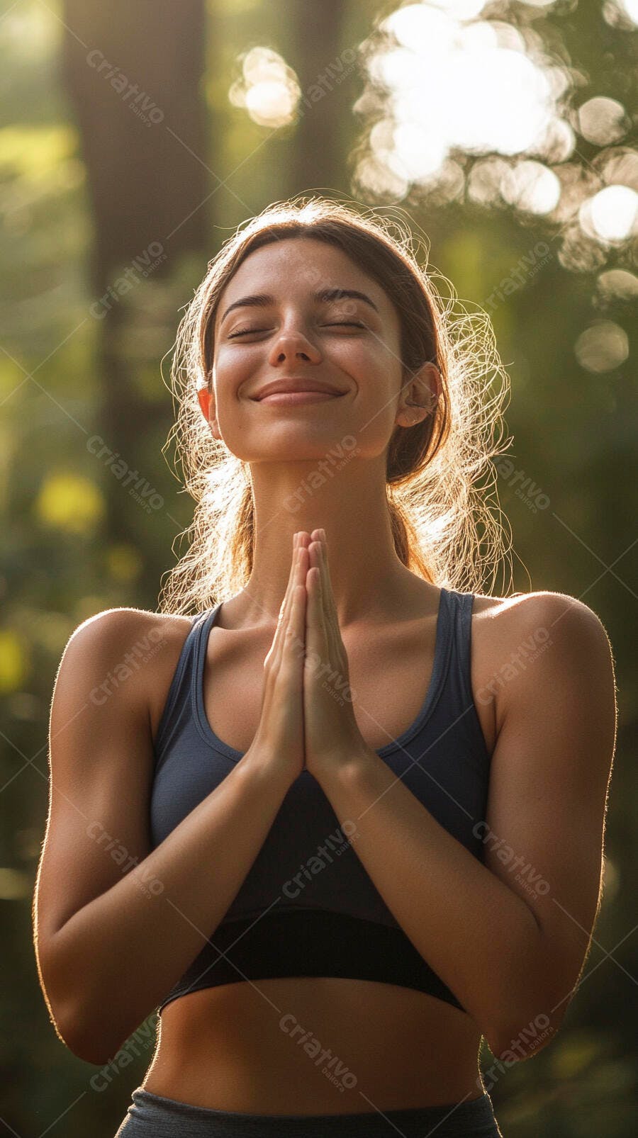 Mulher jovem meditando ao ar livre com as mãos postas ao pôr do sol