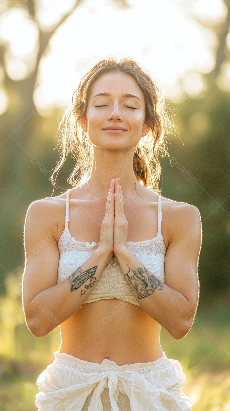 Mulher jovem morena meditando com olhos fechados e mãos em oração na natureza