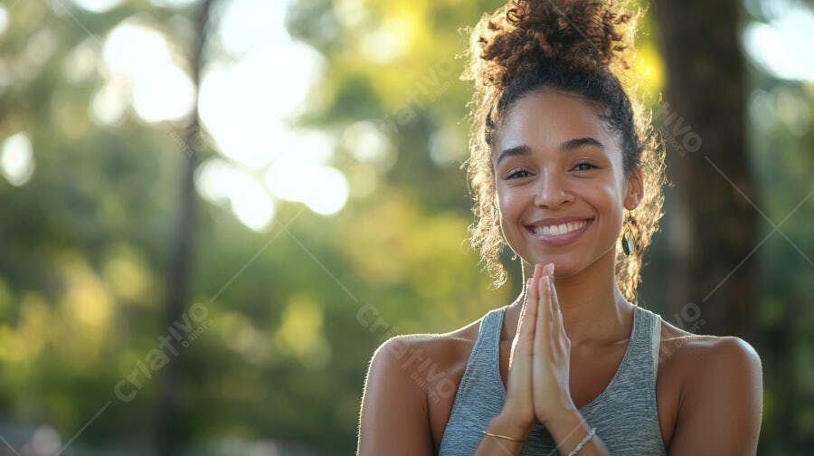 Mulher jovem sorrindo com mãos em oração no parque ensolarado
