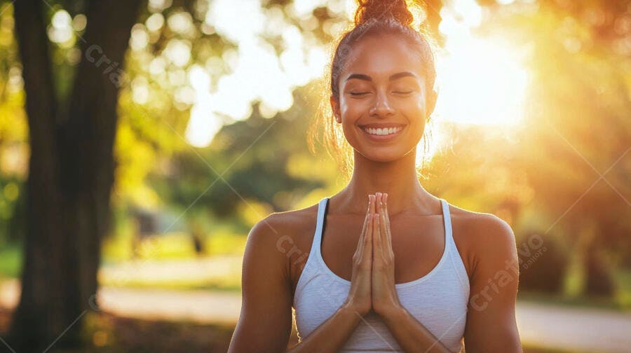 Mulher jovem em meditação no parque ao pôr do sol com luz dourada