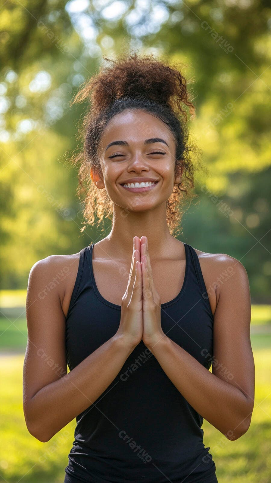 Jovem mulher negra meditando sorrindo no parque ensolarado