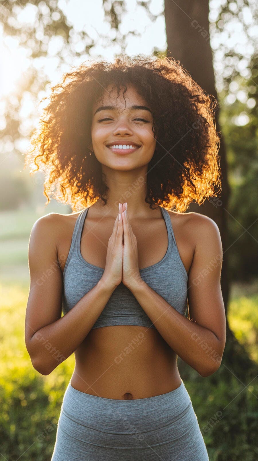 Mulher negra sorrindo em pose de yoga ao pôr do sol