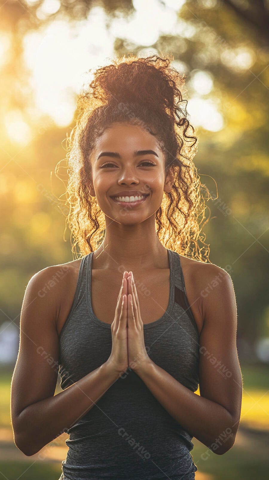 Mulher jovem birracial sorrindo feliz em pose de yoga com luz dourada ao ar livre