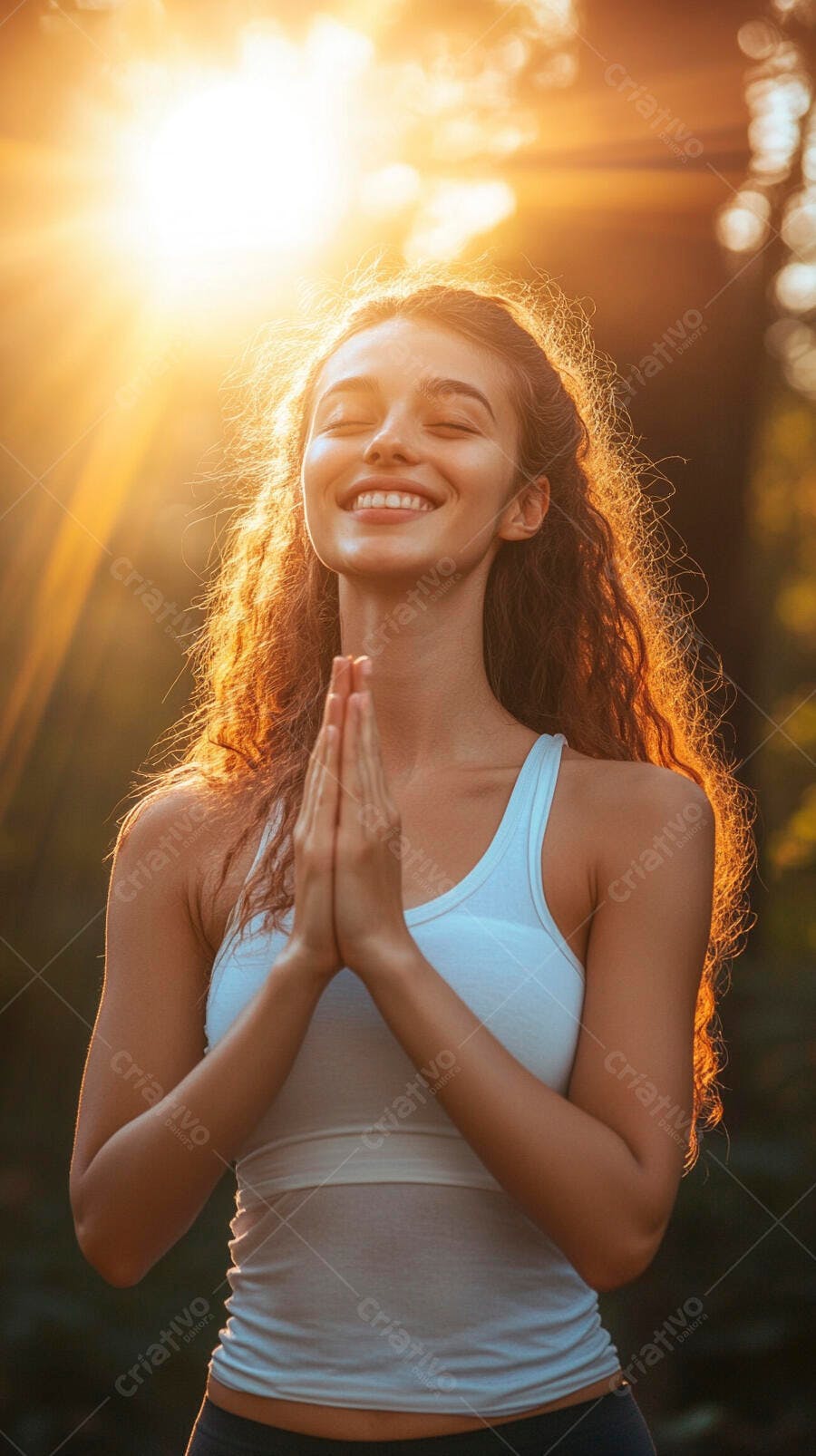 Jovem mulher sorrindo em pose de oração ao pôr do sol