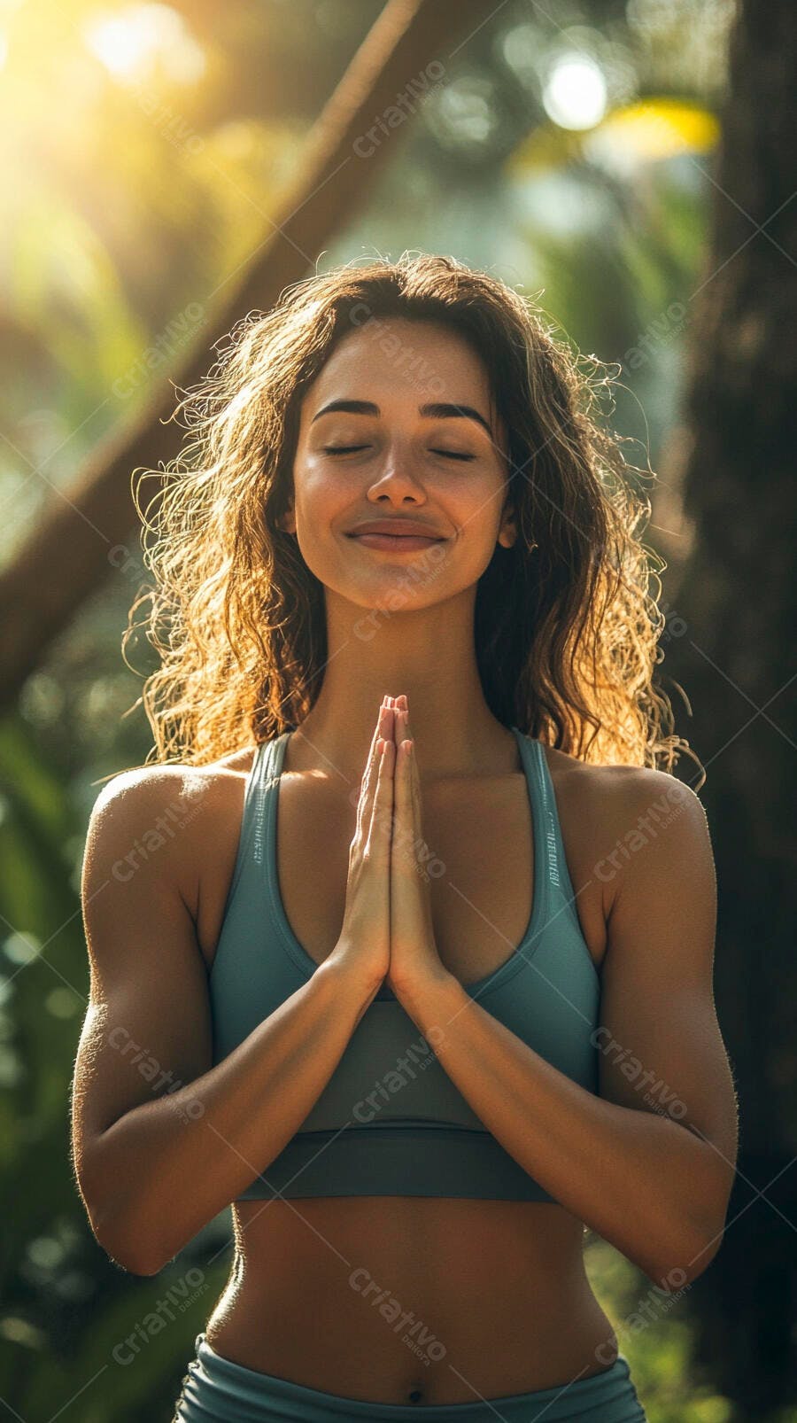 Mulher jovem morena meditando ao ar livre com top verde-azulado na luz dourada do sol