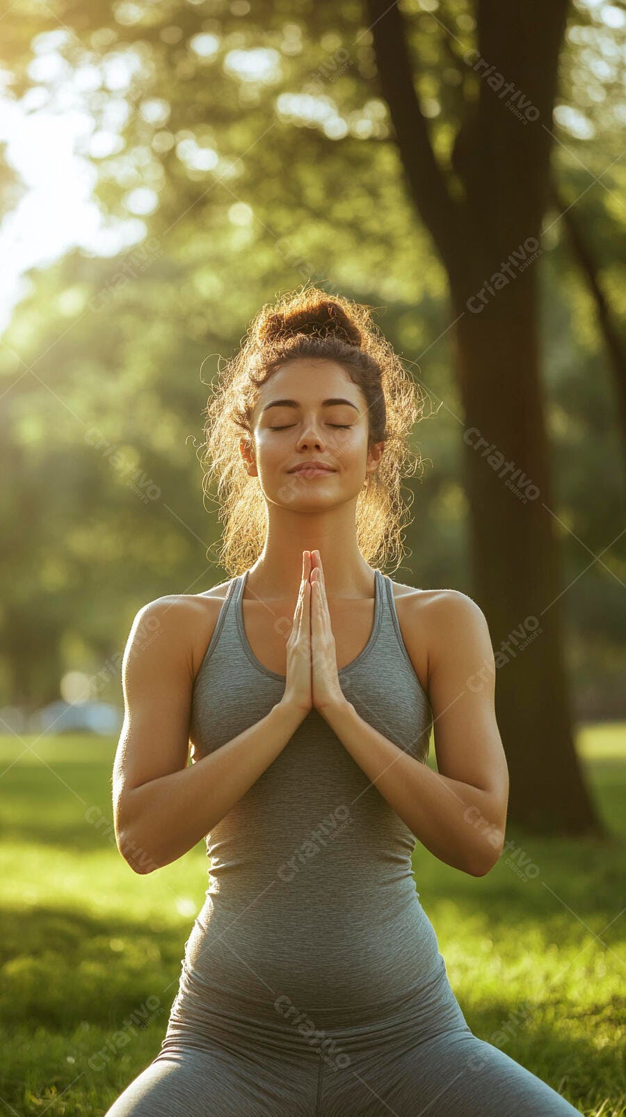 Mulher jovem de cinza meditando em pose de yoga no parque ao pôr do sol