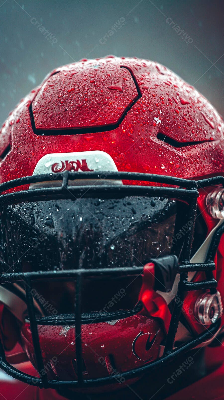 Capacete de futebol americano vermelho molhado sob a chuva intenso detalhe