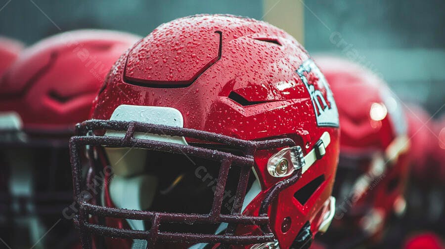 Capacete de futebol americano vermelho com gotas de água em foco