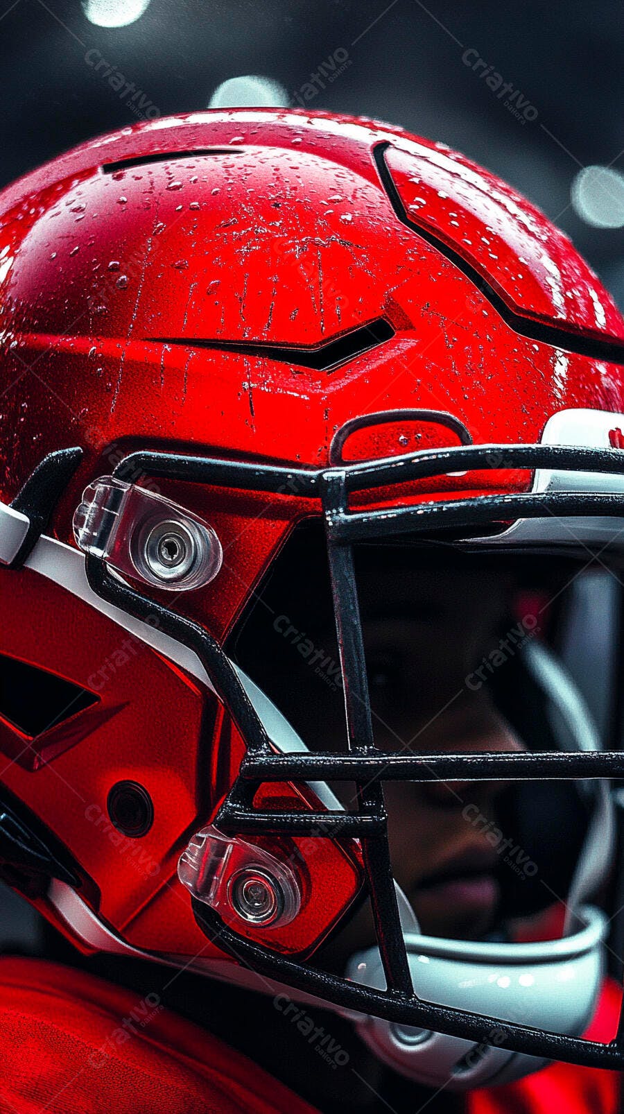 Capacete de futebol americano vermelho molhado com gotas de chuva em jogo noturno