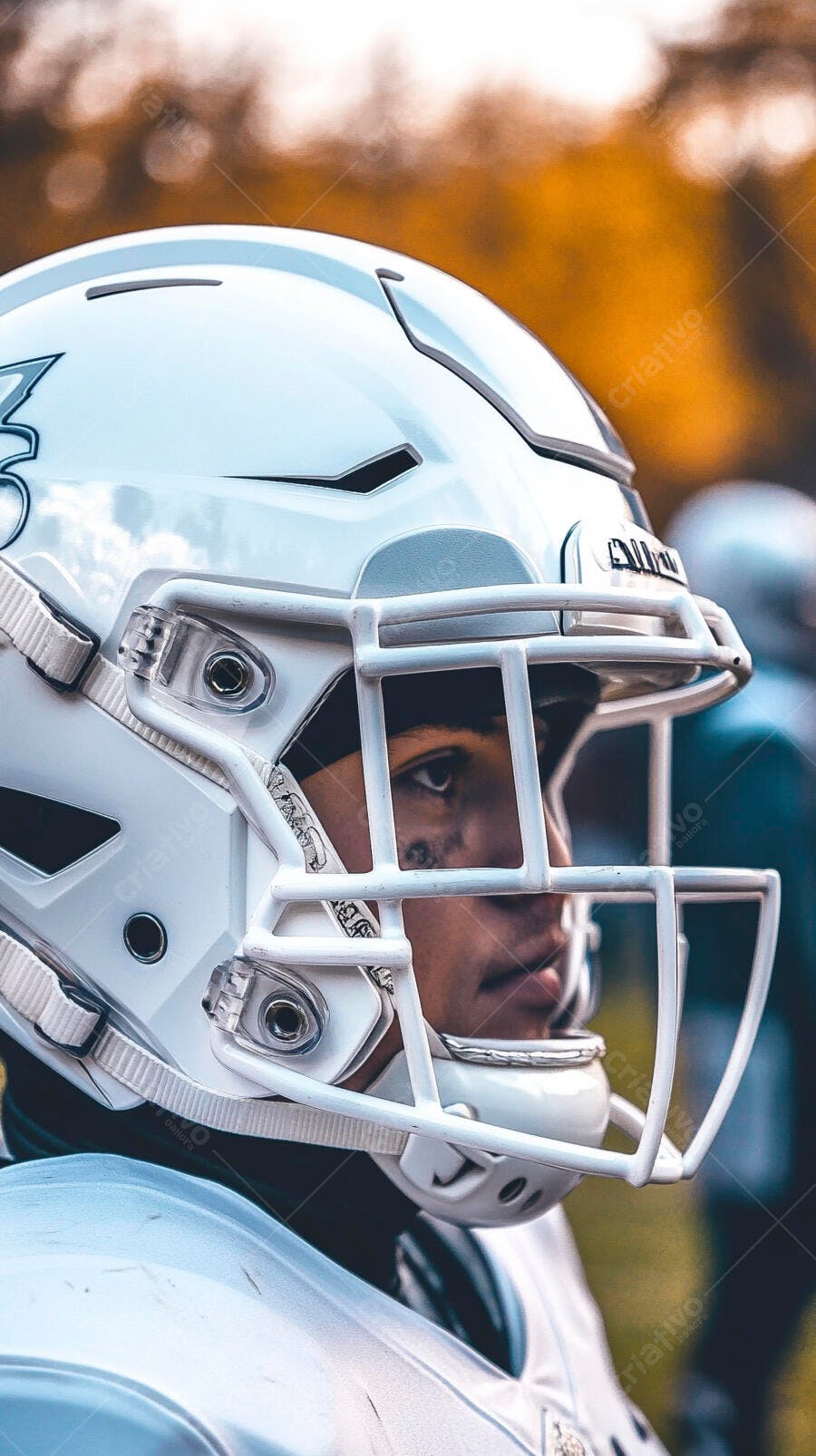Jogador de futebol americano jovem com capacete branco e olho preto em treino no campo