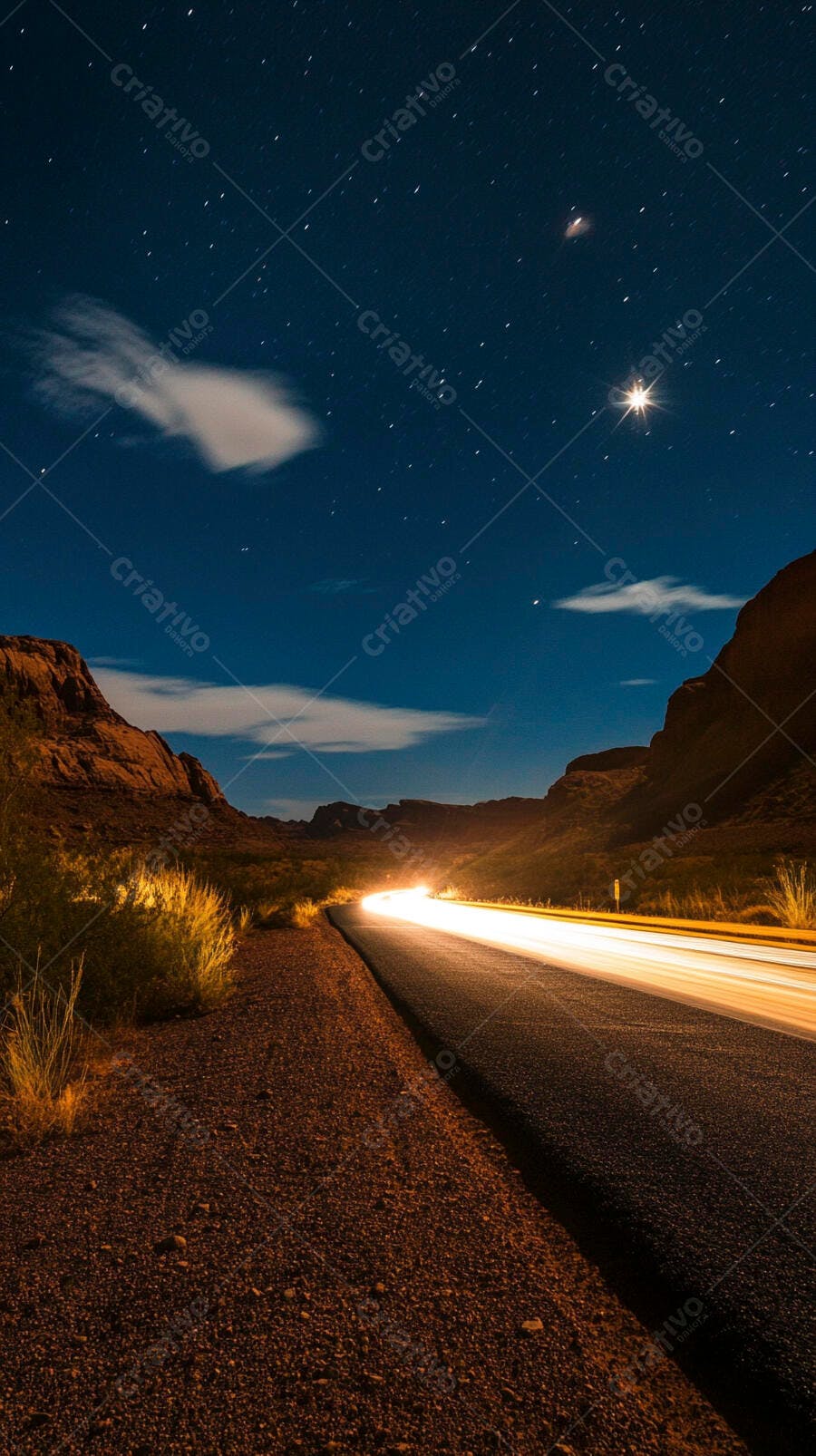 Estrada noturna no deserto com rastros de luz e céu estrelado