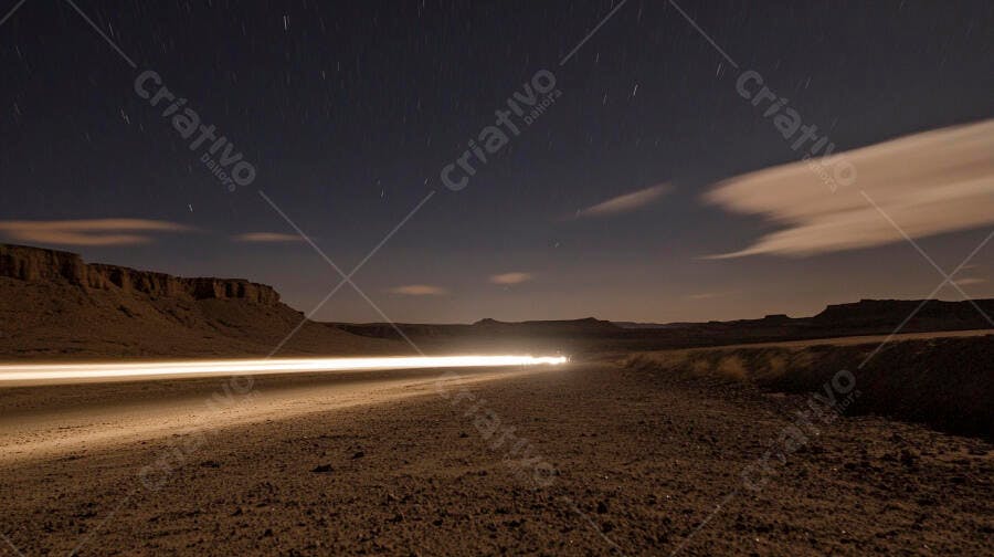 Trilhas de luzes de carro no deserto sob céu estrelado noturno