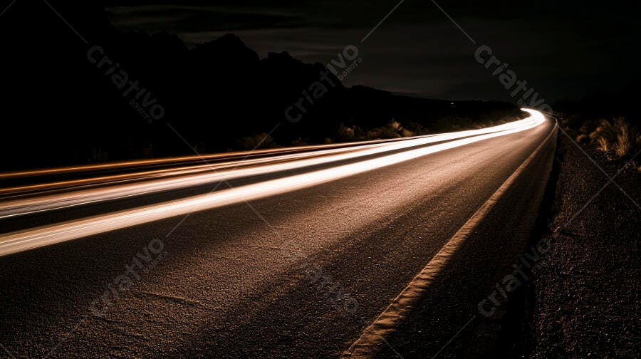 Luzes de carro na estrada sinuosa à noite com montanhas ao fundo