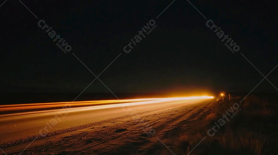 Rastros de luz laranja na estrada escura à noite com longa exposição