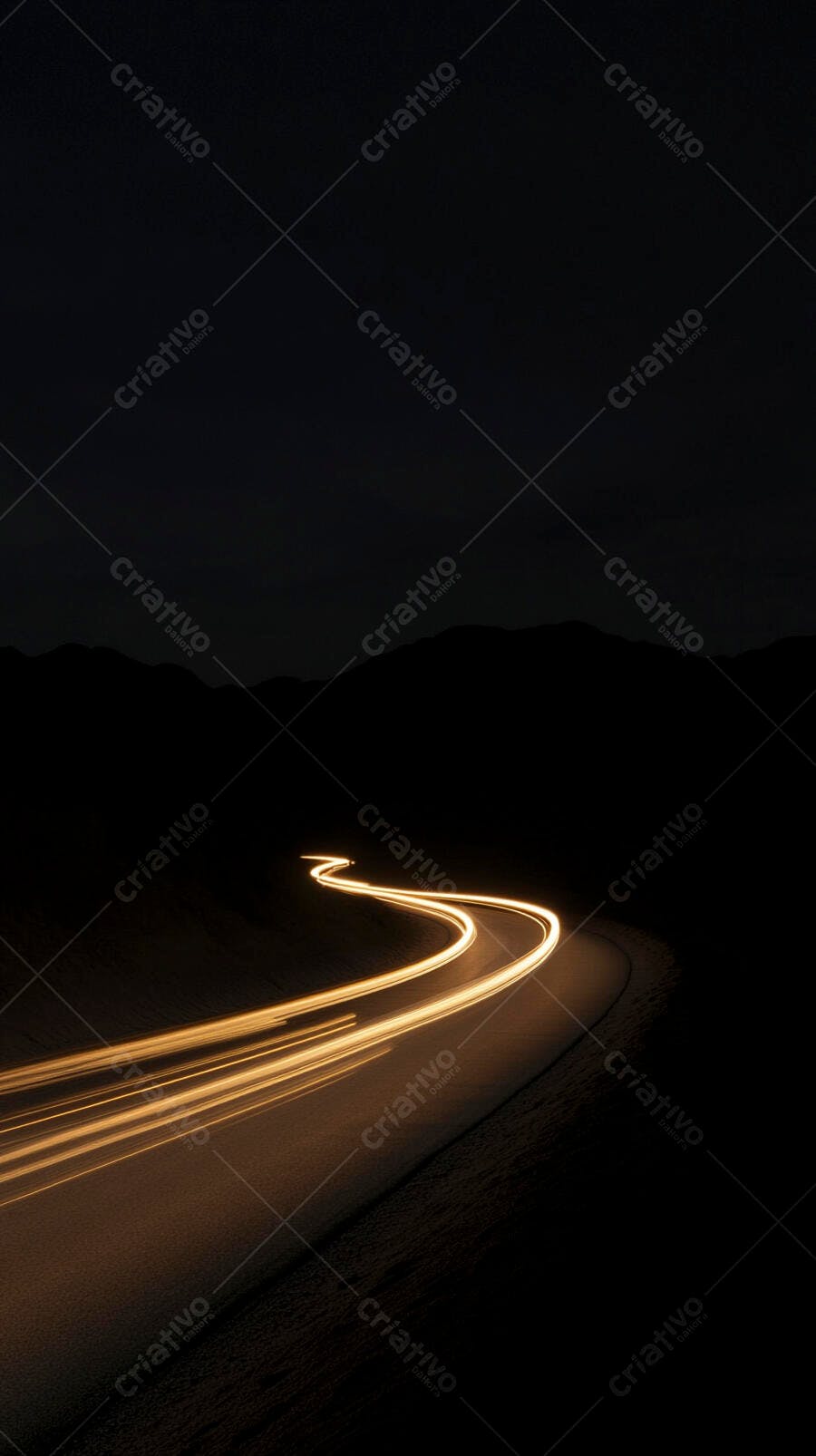 Trilhas de luz na estrada sinuosa à noite
