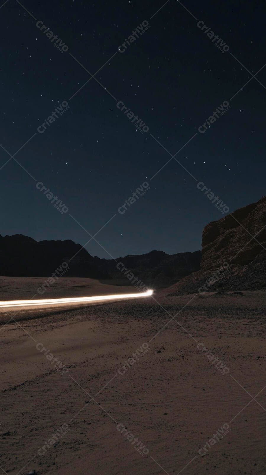 Rastro de luz de carro no deserto sob céu estrelado à noite