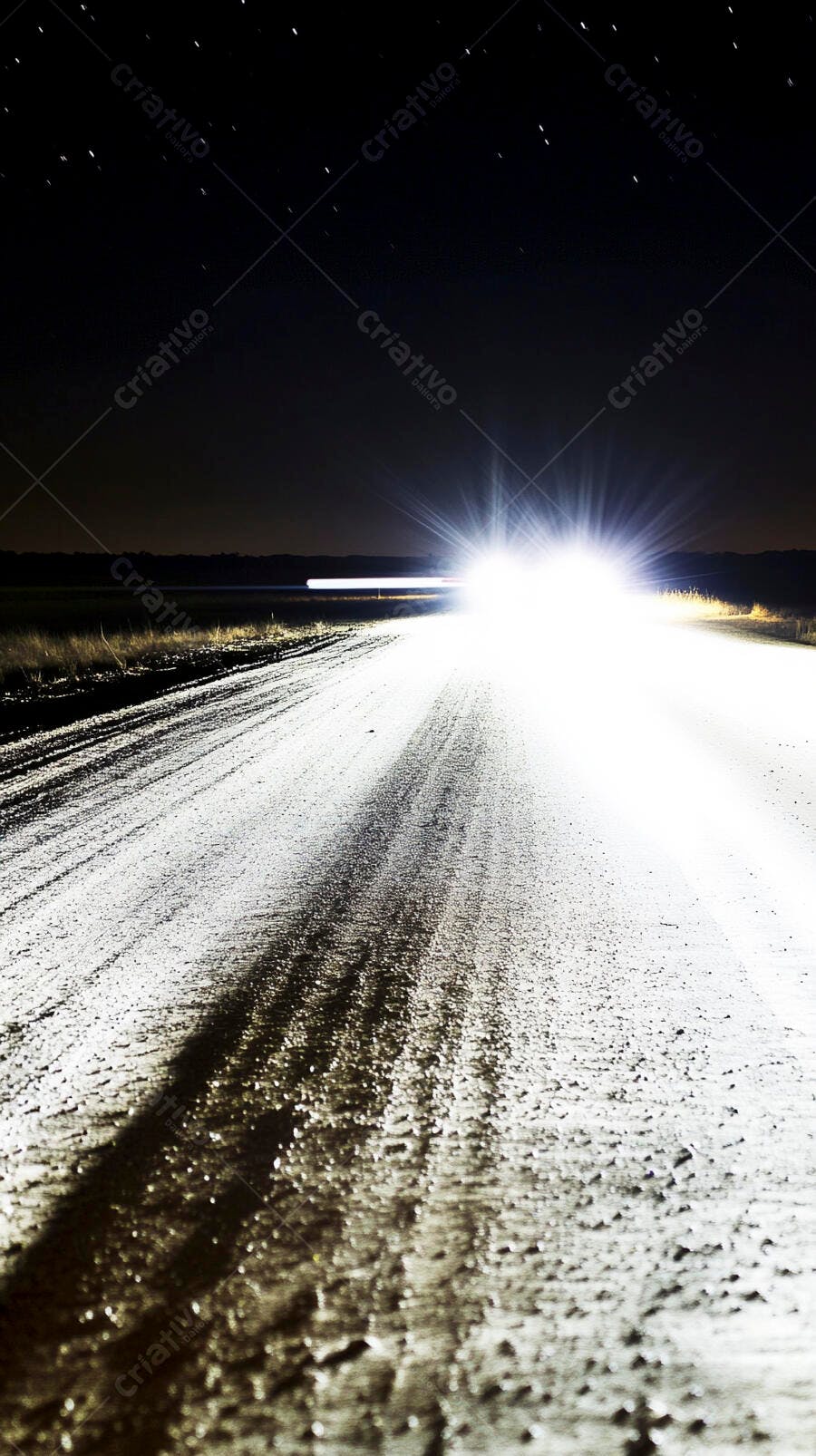 Faróis de carro iluminando estrada de terra escura à noite com estrelas