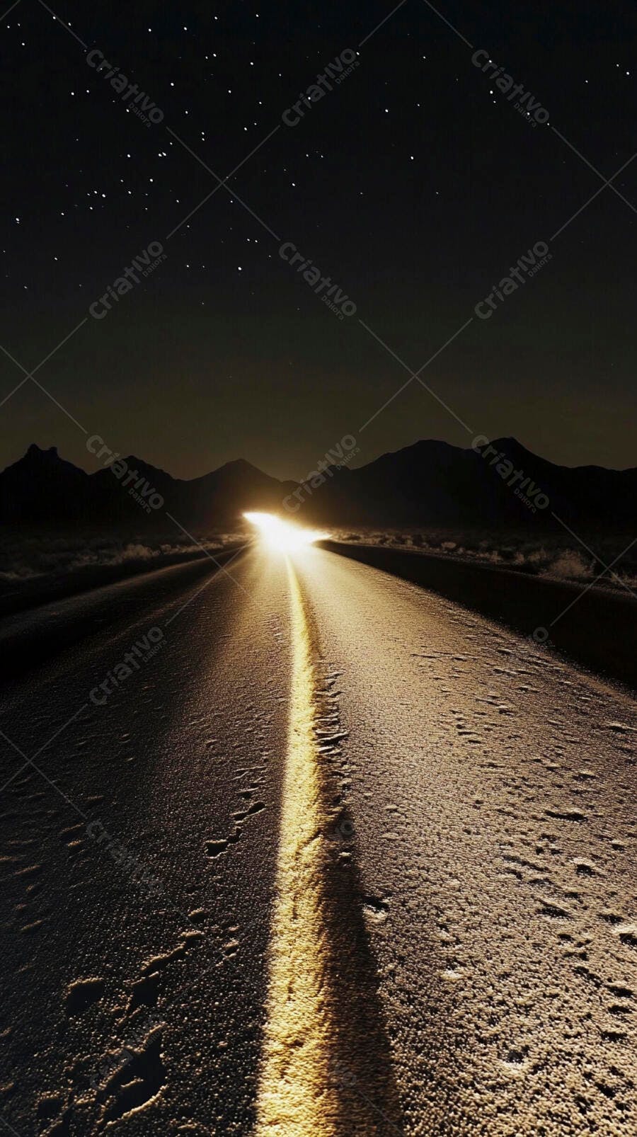 Estrada noturna com luz dourada de faróis sob céu estrelado e montanhas