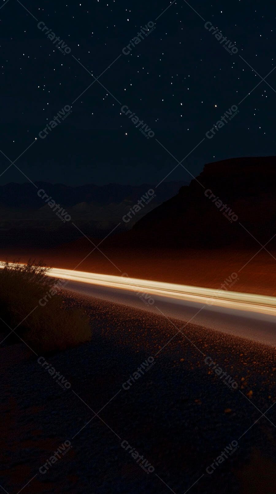 Rastros de luz de carro em estrada do deserto à noite estrelada